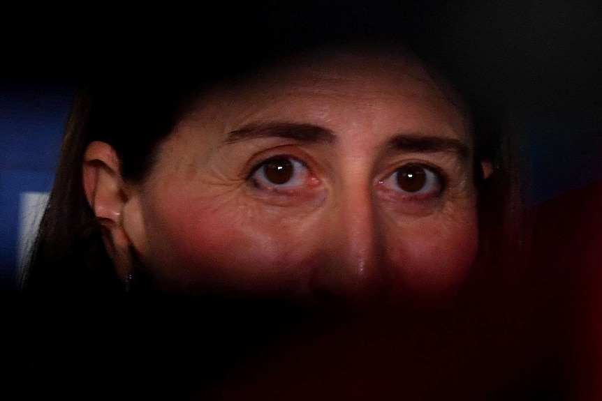 A close up of a woman's illuminated eyes, while the rest of her face is in the dark