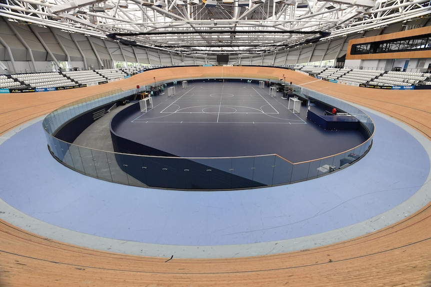 An empty cycling velodrome shows the banking surrounding the cyclists' area in the centre.