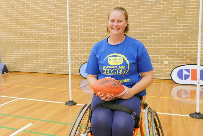 A woman in a wheelchair smiles for the camera.