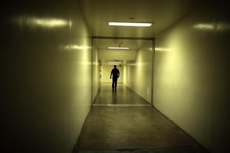 A sheriff's deputy walks down a dark hallway at the Orange County jail in Santa Ana, California