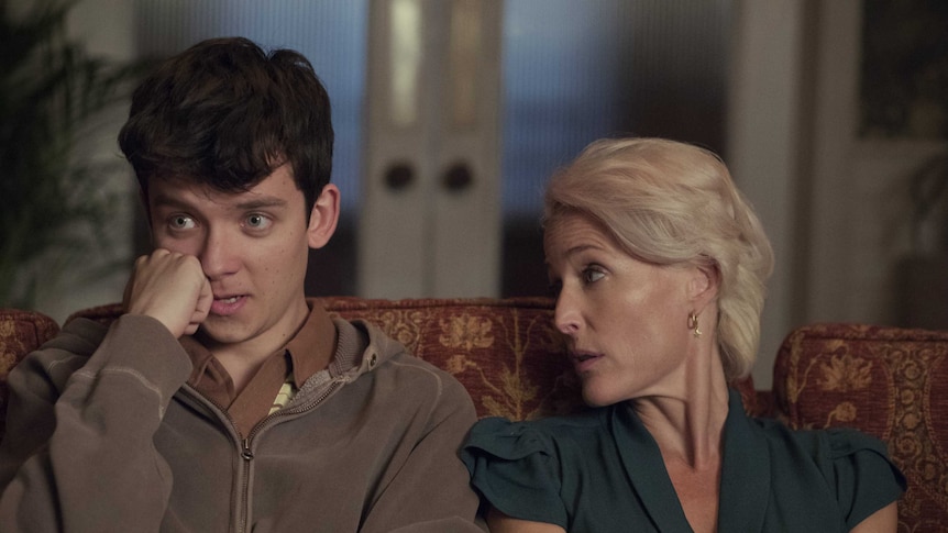 An older woman speaks to a nervous looking teenage boy