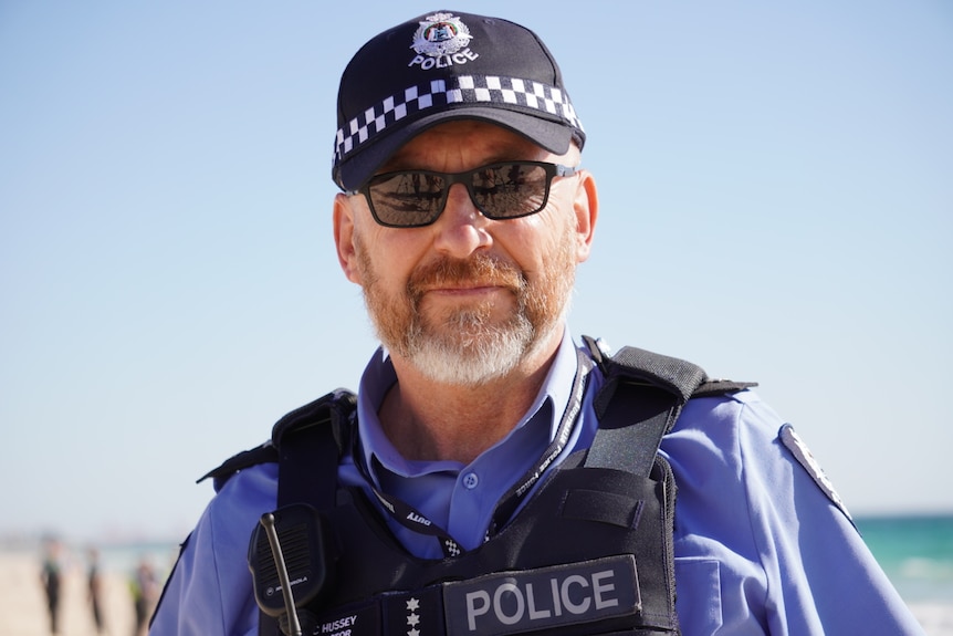 A police officer wearing a hat and sunglasses.
