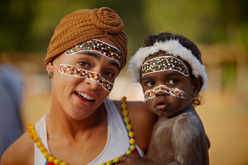 A mother and baby with traditional indigenous face painting