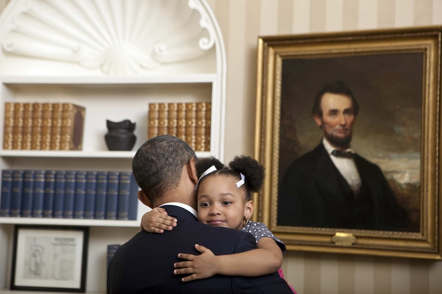 A young girl hugs President Barack Obama in the White House