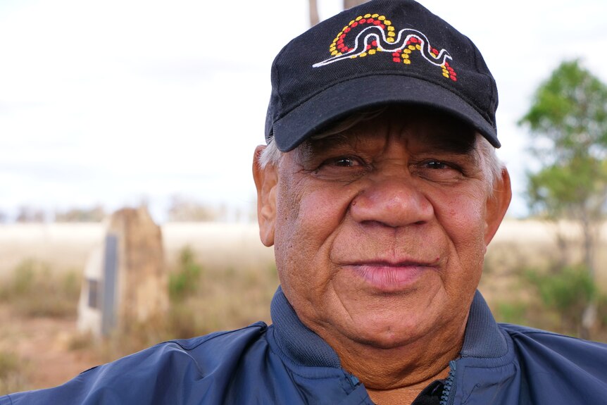 An Indigenous man, Stuart White, wears a black cap.