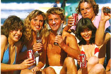 people on a beach smiling with bottles of coca cola in an old vintage photo