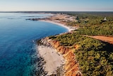 Image of the coastline that shows bright blue sea, white beaches and dense green bushland.