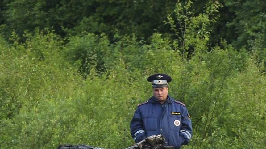 Emergency officials at the scene of a plane crash a kilometre from the runway of Petrozavodsk Airport in northern Russia on June 21, 2011.