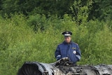 Emergency officials at the scene of a plane crash a kilometre from the runway of Petrozavodsk Airport in northern Russia on June 21, 2011.