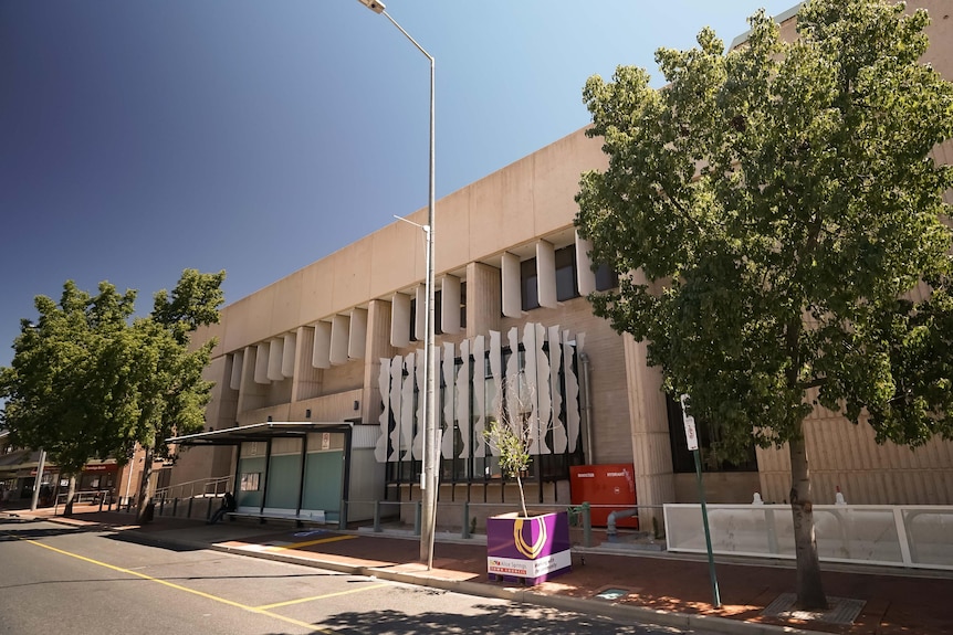 The outside of the Alice Springs court with trees and a bus stop