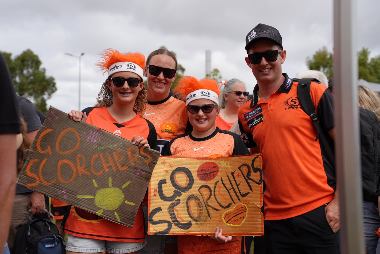 नारंगी रंग के कपड़े पहने बच्चे हाथ में एक चिन्ह लिए हुए हैं जिस पर लिखा है "फिन टैस्टिक" 