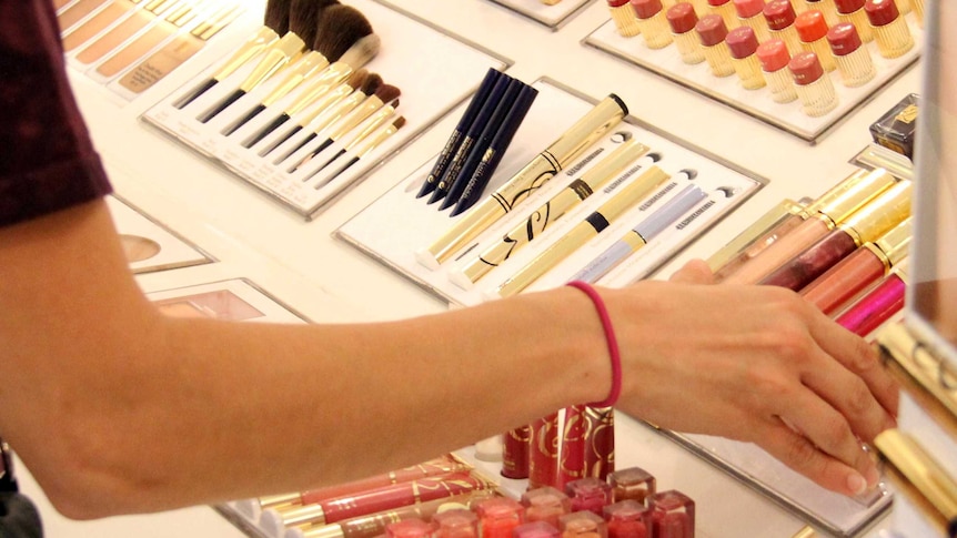A shopper looks at cosmetics in a department store.