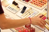 A shopper looks at cosmetics in a department store.