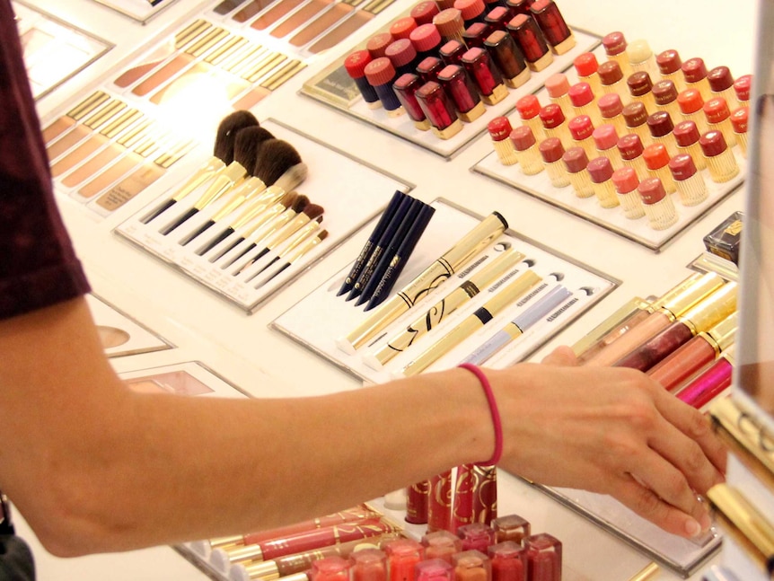 A shopper looks at cosmetics in a department store.