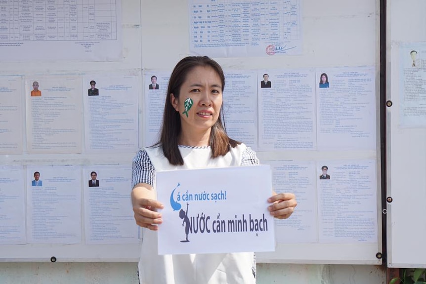 Vietnamese political prisoner Mother Mushroom holds up a sign.