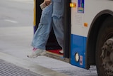 A person getting off a bus in Brisbane.