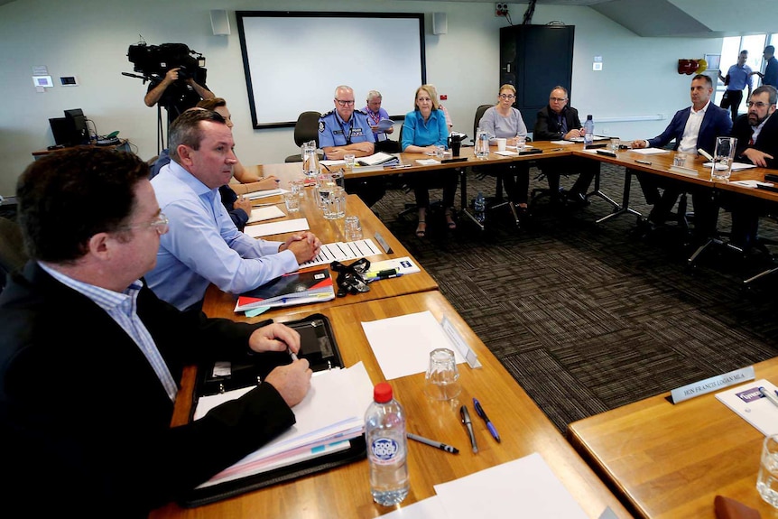 WA Government politicians sit around a large made-up table with the WA Police Commissioner during a meeting.
