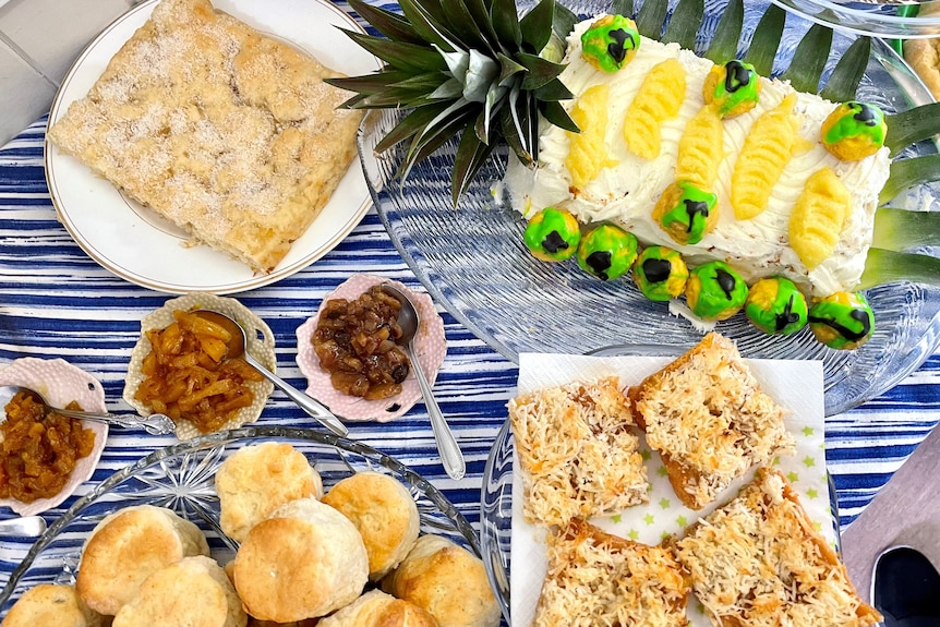 Scones, a bright pineapple cake, chutneys in little dishes and pineapple slices.