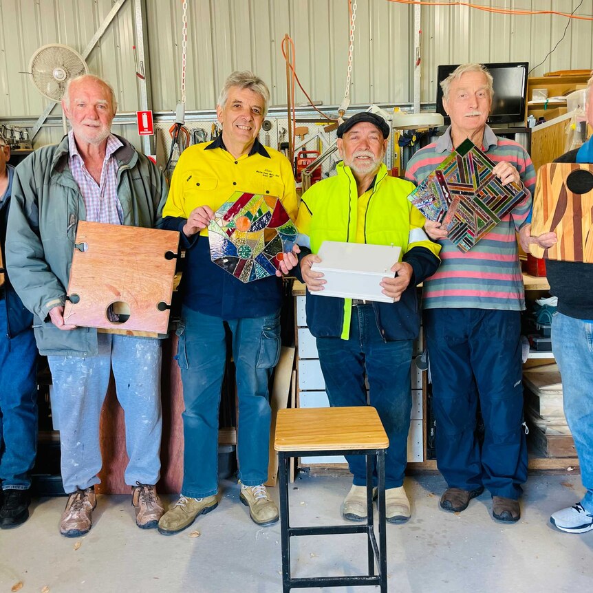 Members of the Weston Creek Men's Shed in Rivett display some examples of reject projects.