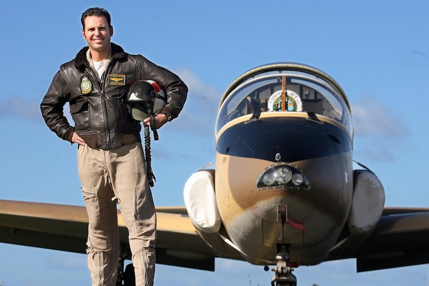 Daniel Duggan stands in front of a plane 