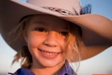 A young girl with a large Akubra hat with text across it saying #stopbullyingnow