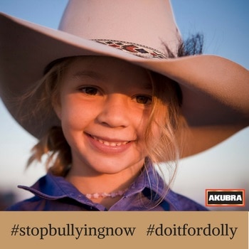 A young girl with a large Akubra hat with text across it saying #stopbullyingnow