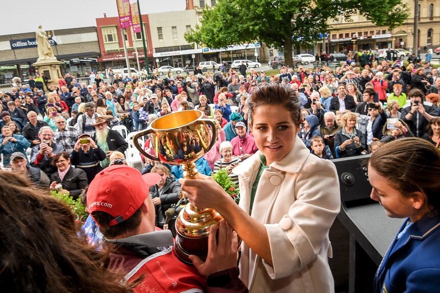 Melbourne Cup-winning jockey, Michelle Payne, and her brother, Stevie, hold the Melbourne Cup in Ballarat.