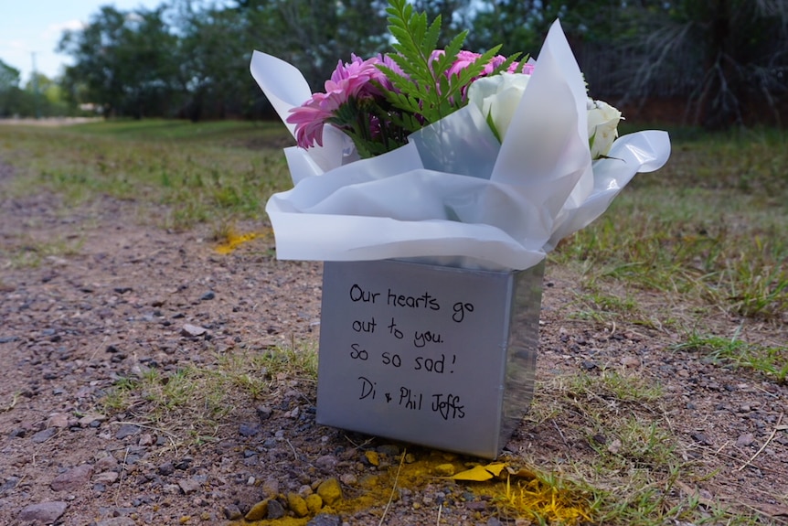 Pink and white flowers in a white box on the side of a road where a teenage girl was killed