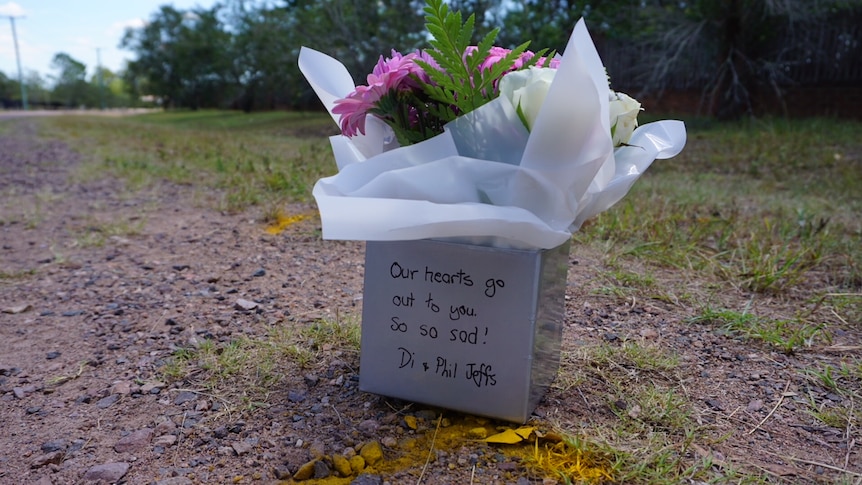 Pink and white flowers in a white box on the side of a road where a teenage girl was killed
