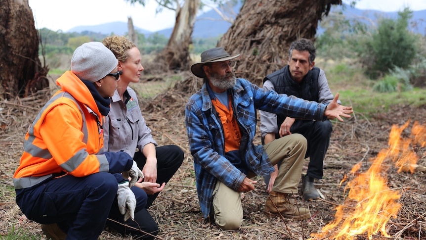 Dave Wandin gestures to a flame burning as part of a cultural burn at Coranderrk Station.