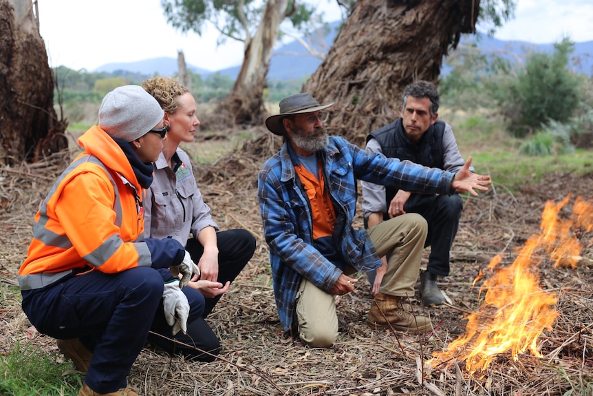 Dave Wandin gestures to a flame burning as part of a cultural burn at Coranderrk Station.