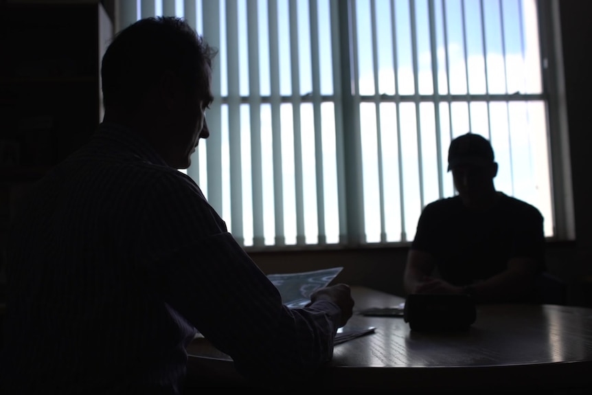 Two silhouetted figures in a room.