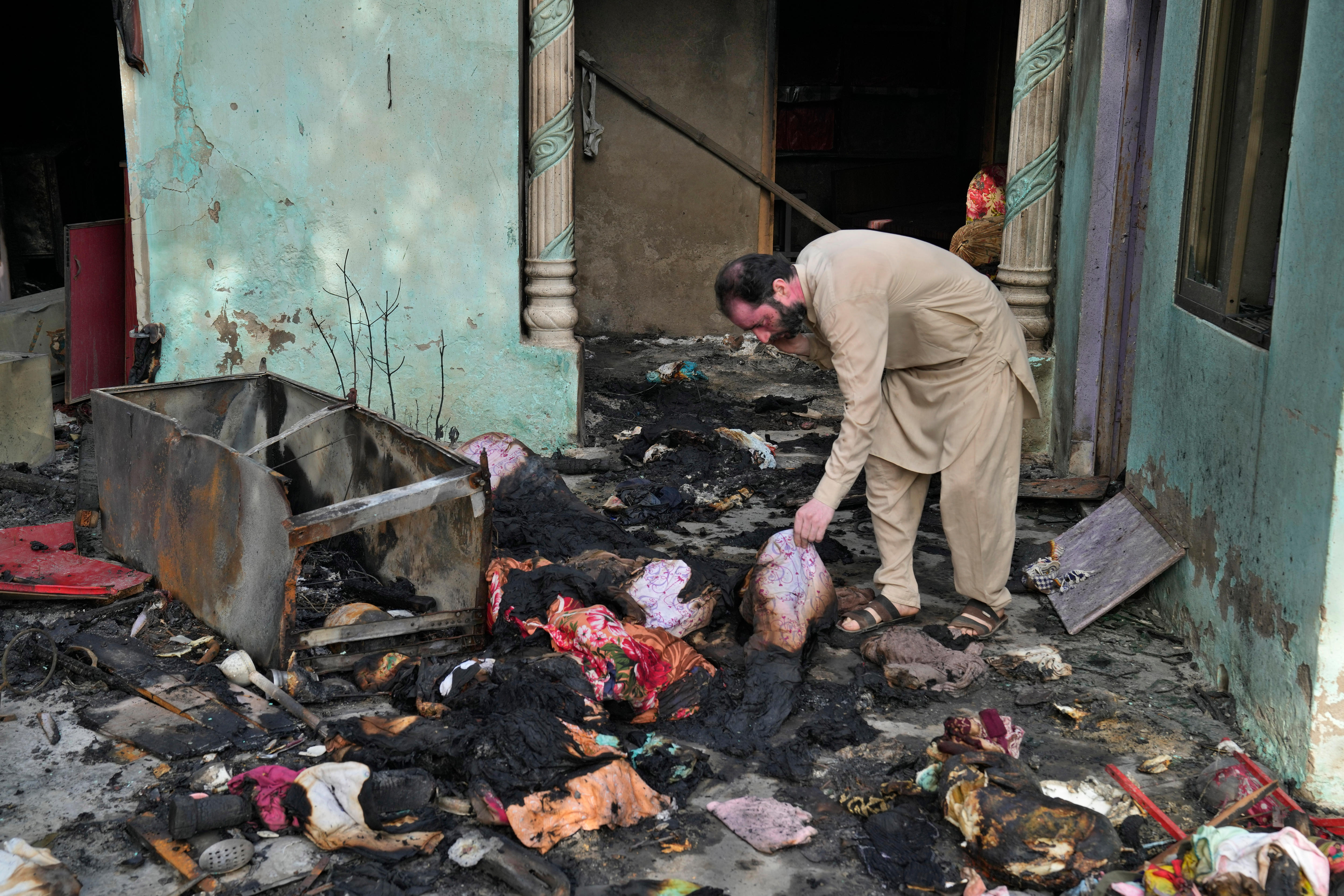 A Christian man checks a home vandalized by angry Muslim mob.