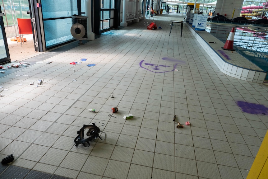 A tiled floor with items strewn around on it.