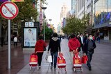 People walk with their shopping carts at a shopping area in Shanghai