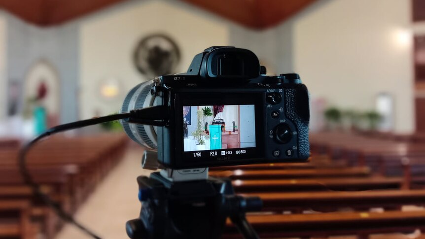 A camera inside a chapel with its screen showing the scene, ready to stream a funeral.