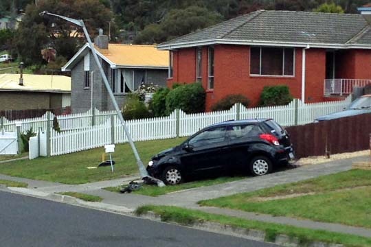 A car rests up against a lightpole after a crash in Hobart which injured two pedestrians.