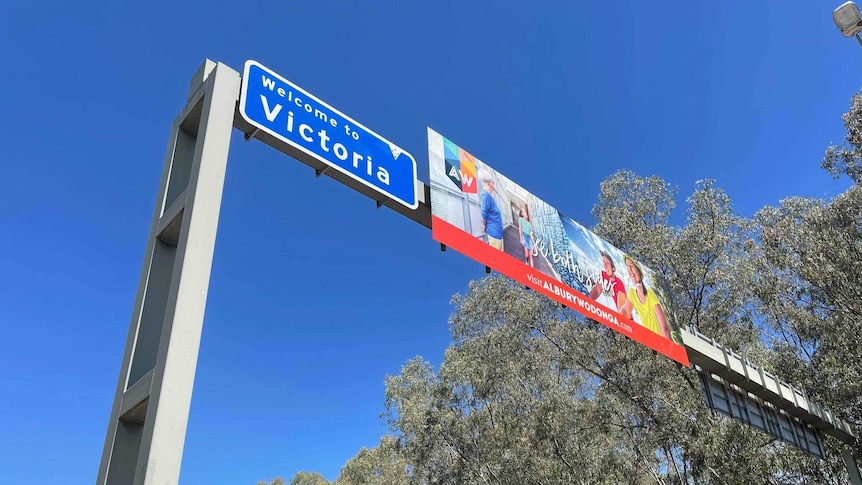 A country road with a sign above saying Welcome to Victoria