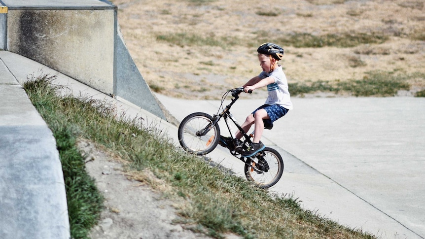 boy riding a bike up a hill