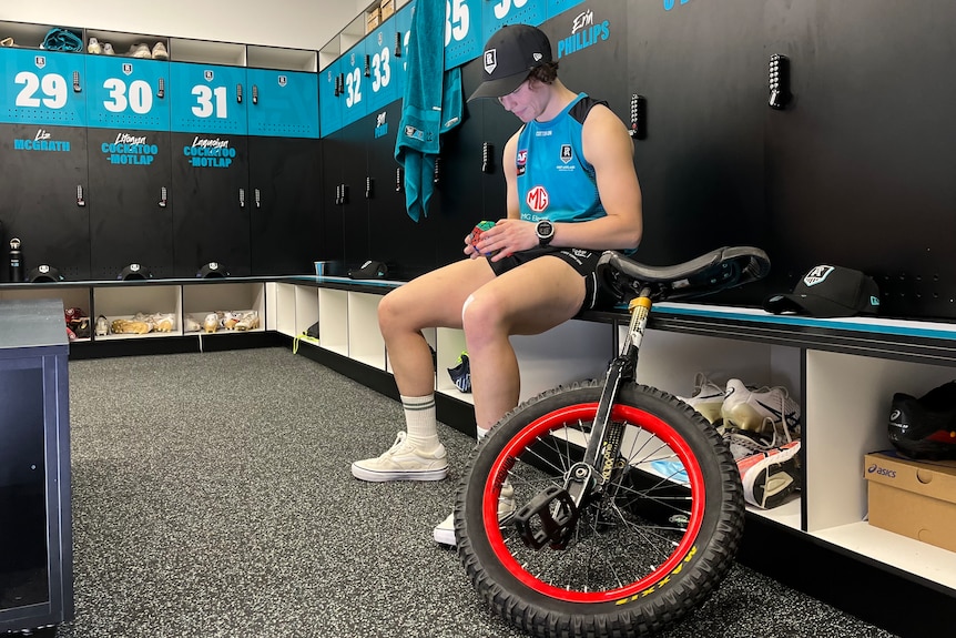 Ebony O'Dea sits in the Port Adelaide locker room with her Rubik's cube and unicycle