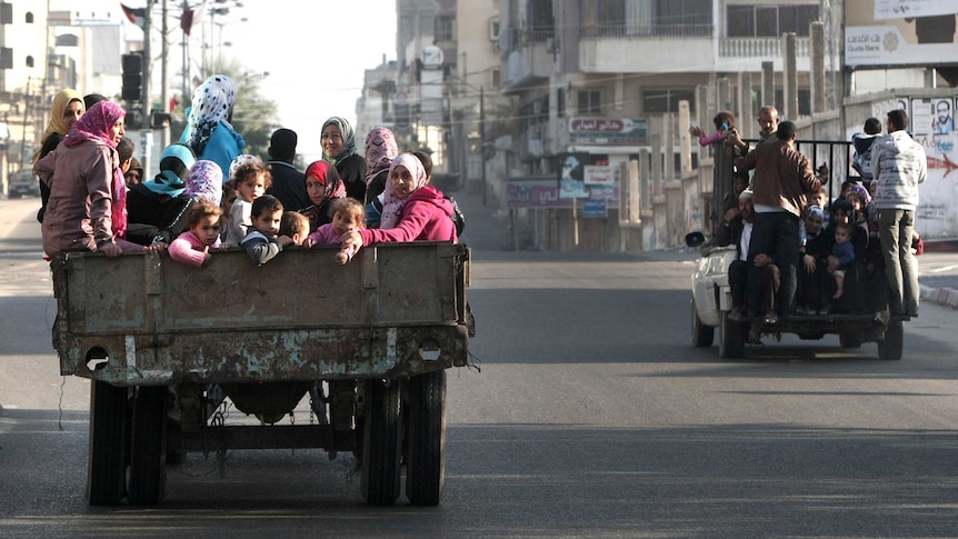 Palestinian families are evacuated after Israeli air strike in Gaza City.