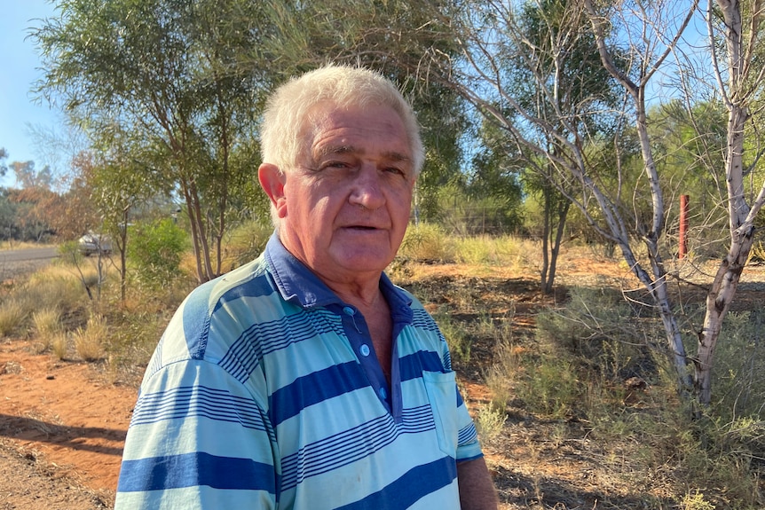 An elderly man staads in the outback