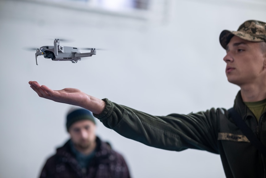An instructor launches a quadcopter