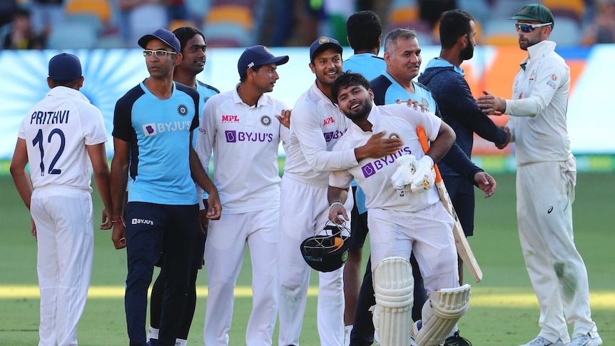 India’s players and support staff embrace as they celebrate beating Australia in the fourth Test in Brisbane.