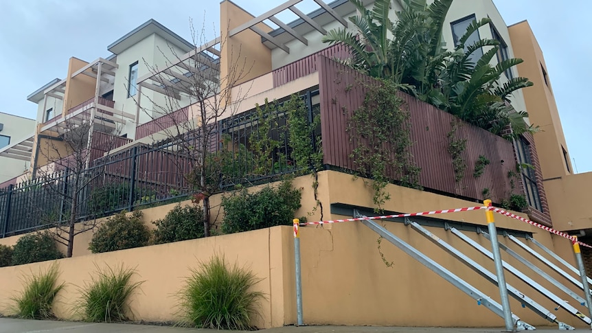 Metal bars hold up a wall of an apartment building.