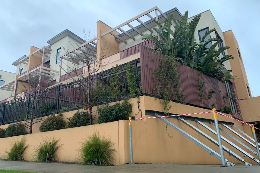 Metal bars hold up a wall of an apartment building.