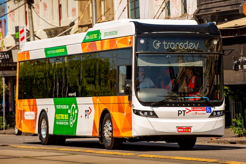 A fully electric bus drives down a street in inner Melbourne.