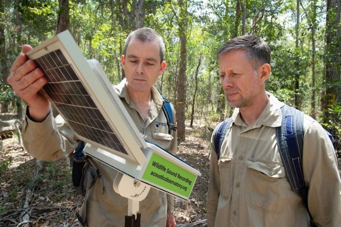 Researchers check on an acoustic sensor in the field