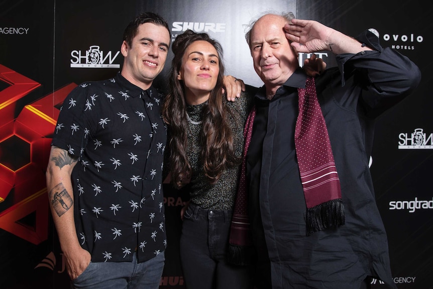 Three people smiling at the camera.