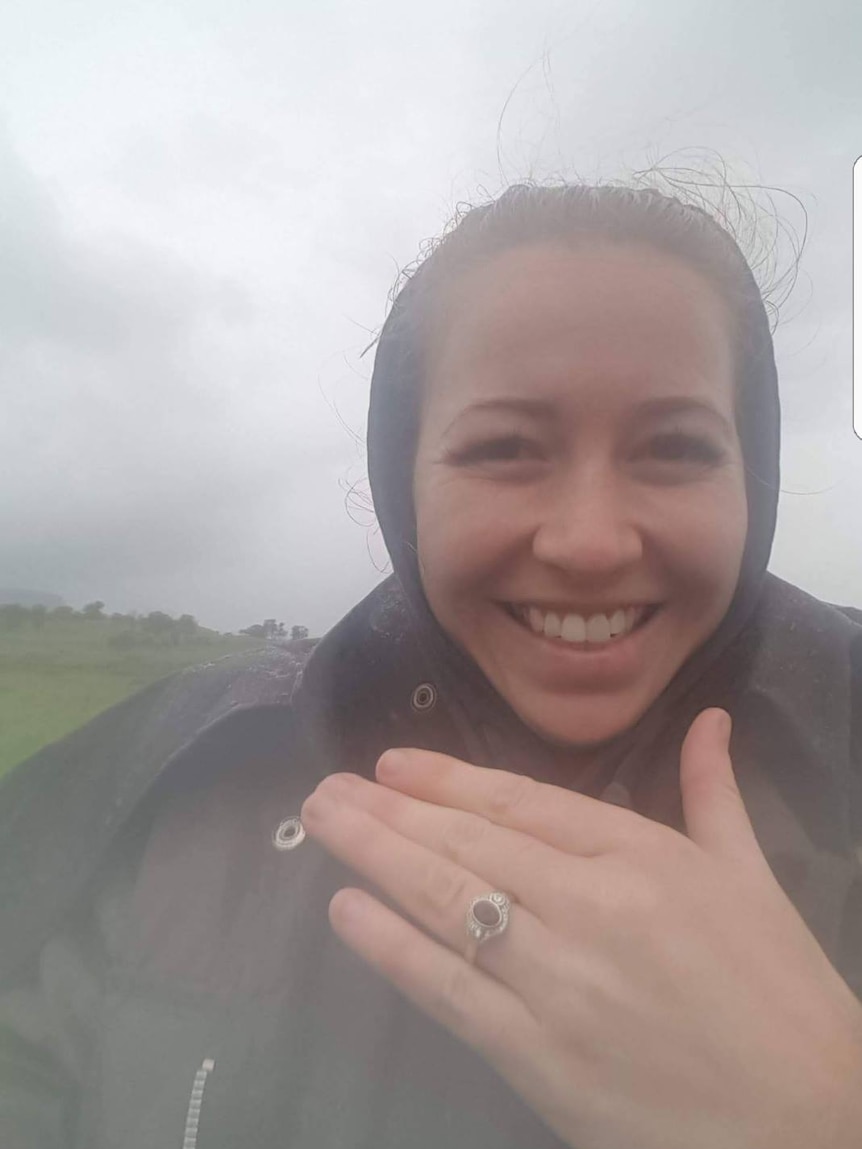 Elizabeth Docherty in the rain shows off her wedding ring
